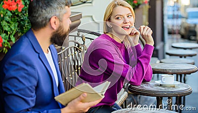 Girl interested what he reading. Meeting people with similar interests. Man and woman sit cafe terrace. Literature Stock Photo