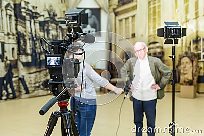 The girl interviews the man. Video shooting in the interior. LCD display on the camcorder Editorial Stock Photo