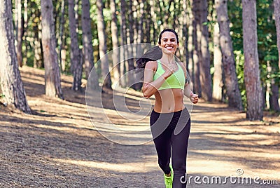 A girl jogging in the woods outdoors. Stock Photo