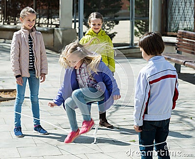 Girl jumping with skipping rope among friends Stock Photo