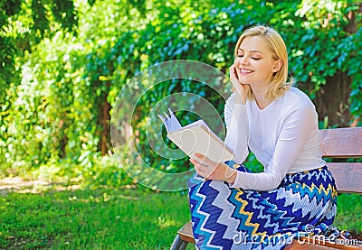 Girl keen on book keep reading. Reading literature as hobby. Woman blonde take break relaxing in park reading book. Girl Stock Photo