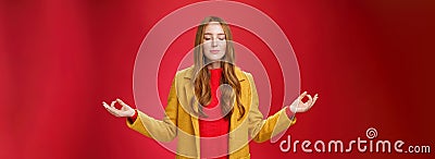 Girl keep calm releasing stress with meditation, posing in yellow coat, close eyes and looking relieved as extending Stock Photo