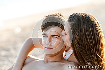 Girl kissing boy at sunset. Stock Photo