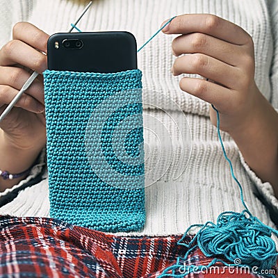 Girl knits a woolen smartphone case Stock Photo