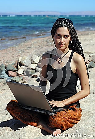 Girl with laptop on a beach Stock Photo