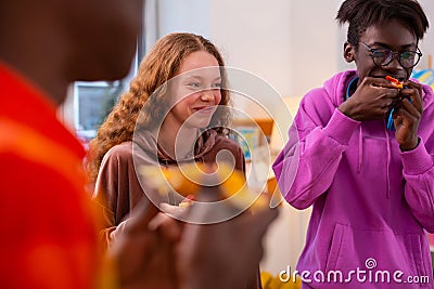 Girl laughing while having little pizza party with best friends Stock Photo