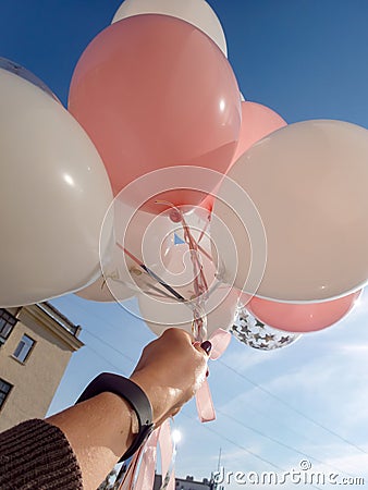 A girl launches balloons into the sky Stock Photo