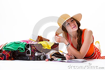 Girl lays beside open suitcase. Stock Photo