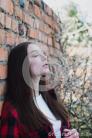 Girl leaned against a brick wall, portrait of a cute girl Stock Photo