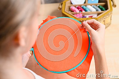 The girl is learning to embroider. Stock Photo