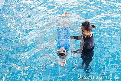 Girl learning to swim with coach Stock Photo