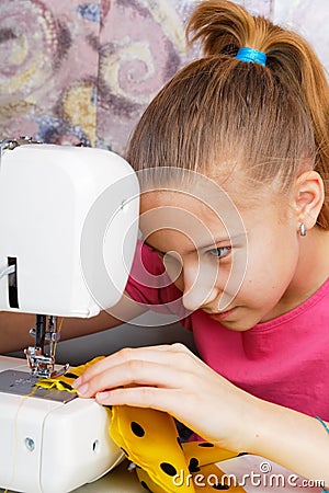 Girl learns to sew Stock Photo