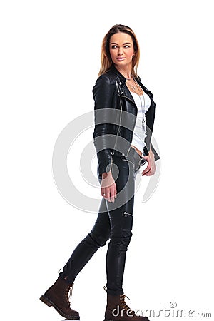 Girl in leather jacket pose walking in studio background while l Stock Photo