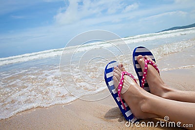 Girl legs in colorful flipflop on beach Stock Photo