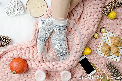 Girl legs in a socks on Merino wool blanket, trendy concept. Close-up flatly Stock Photo