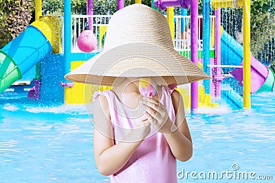 Girl licks ice cream at pool Stock Photo