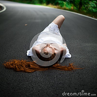Girl lie on a road - hitchhiking Stock Photo