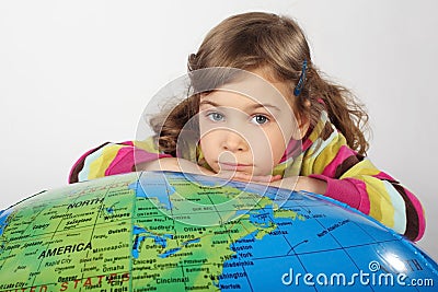 Girl lies on big inflatable globe, chin on hands Stock Photo