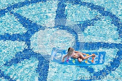 A girl lies on mattress in the pool Stock Photo