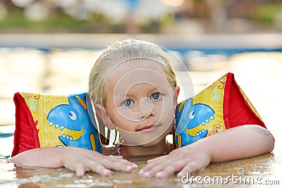 Girl in a life jacket swims in the pool Stock Photo