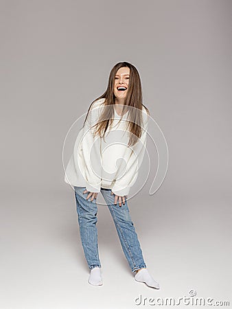 Girl in light jeans and a white oversized sweater Stock Photo