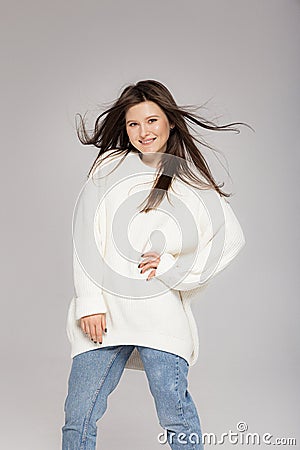 Girl in light jeans and a white oversized sweater Stock Photo