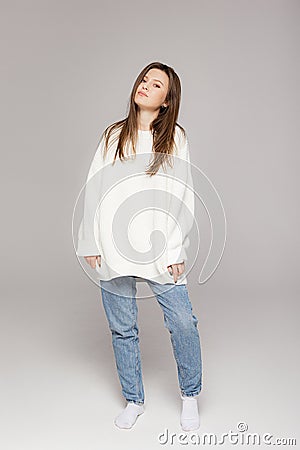 Girl in light jeans and a white oversized sweater Stock Photo