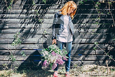 Girl with a lilac bouquet of lilac in the garden. girl tearing the lilac in the garden Stock Photo