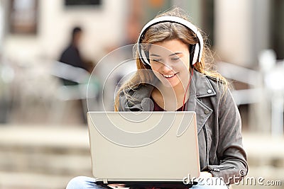 Girl listening and downloading music from laptop Stock Photo