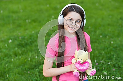 Girl listening summer melody wireless headphones nature background, happy childhood concept Stock Photo