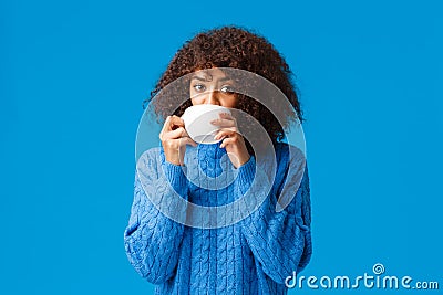 Girl listening to fresh gossips and sipping tea. Intrigued and relaxed good-looking african american woman having Stock Photo