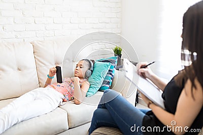 Girl Listening To Music To Neglect Psychologist At Home Stock Photo