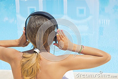Girl listening to music by the pool Stock Photo