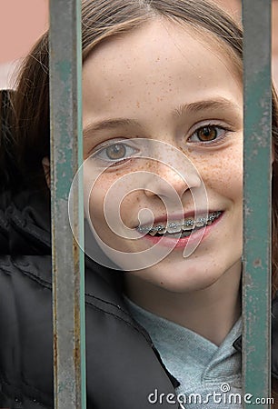 Girl locked in behind a fence Stock Photo
