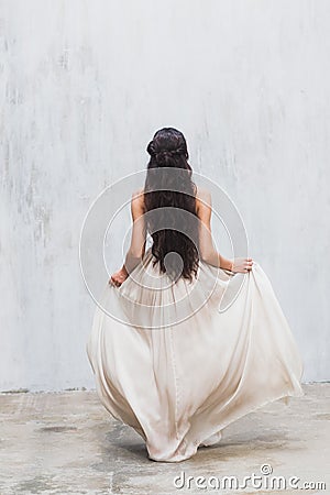 Girl with long black hair in a gentle silk wedding dress Stock Photo