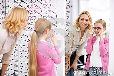 Girl look herself in the mirror with new eyeglasses Stock Photo