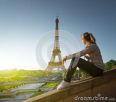 Girl looking at the Eiffel tower in sunrise time Stock Photo