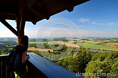 Girl looking from lookout tower to green czech countryside Stock Photo