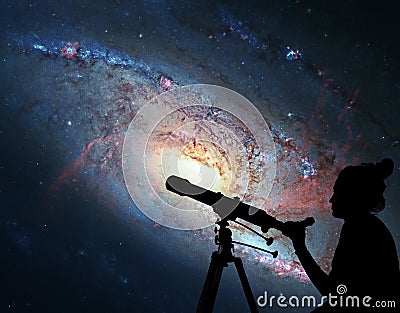 Girl looking at the stars with telescope. Spiral Galaxy M106 Stock Photo