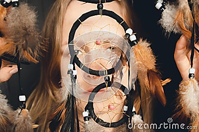 The girl looks through the catcher`s ring of dreams with her beautiful and wide-open eyes. Stock Photo