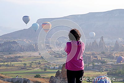 Girl looks at the flight of balloons in Cappadocia. Turkey Editorial Stock Photo