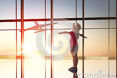 Girl looks at a plane at the airport Stock Photo