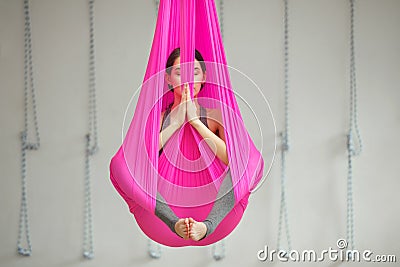 Girl lotus pose aerial antigravity yoga. Woman sits in hammock Stock Photo