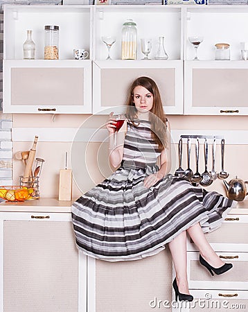 Girl lush gray dress sitting in the kitchen Stock Photo