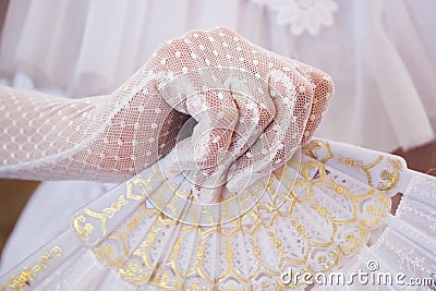 Girl in a lush white dress and in white gloves with beautiful hand fan Stock Photo