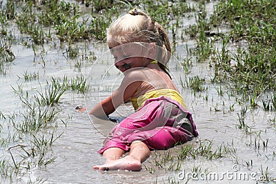 Girl lying in muddy water Stock Photo