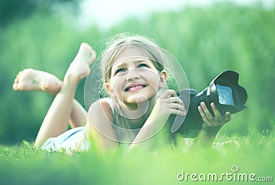 Girl lying in park with camera Stock Photo