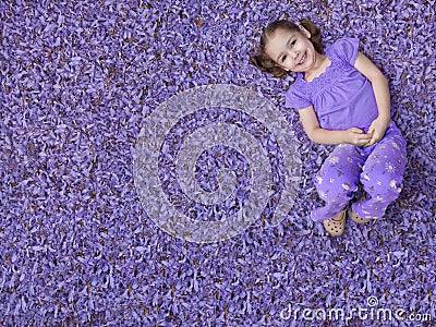 Girl lying on purple flowers Stock Photo