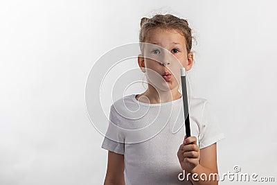 Girl magician - magic wand in child hands - young magician performing with a magic wand - frontal view against white background Stock Photo