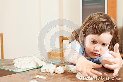 A girl makes dough figurines Stock Photo